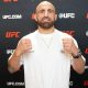 De punhos cerrados e camisa branca, Volkanovski posa para foto durante o media day do UFC 314
