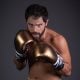 Duda Nagle com os punhos cerrados de luva dourada de boxe